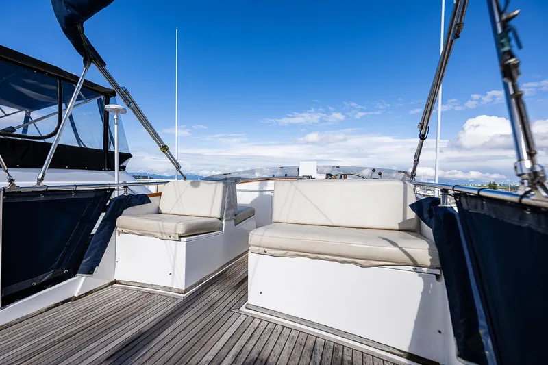 Vesper Yacht Photos Pics 1990 Grand Banks Sedan yacht deck with seating under clear blue sky.