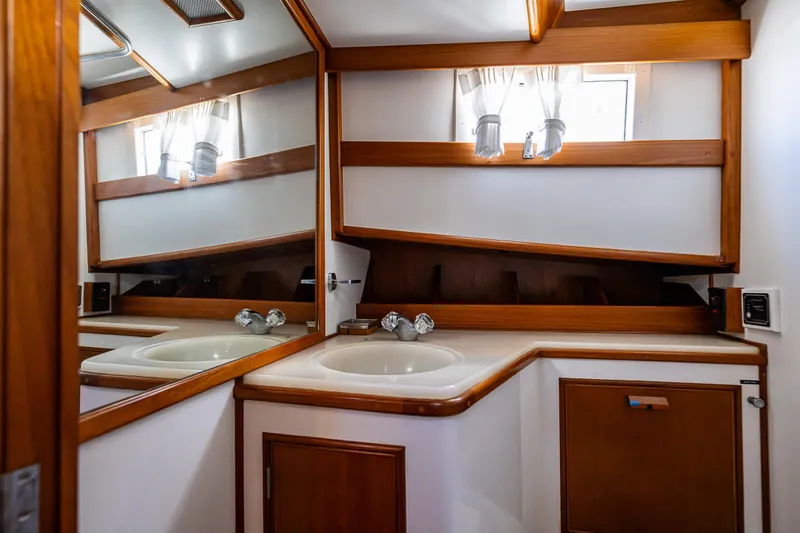 Vesper Yacht Photos Pics 1990 Grand Banks Sedan bathroom with wooden accents and mirrored walls.