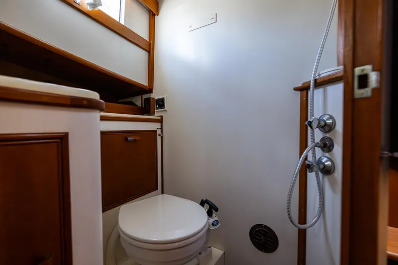 Vesper Yacht Photos Pics 1990 Grand Banks Sedan boat bathroom with wooden cabinets and shower.