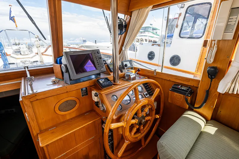Vesper Yacht Photos Pics 1990 Grand Banks Sedan boat helm with navigation equipment and wooden steering wheel.