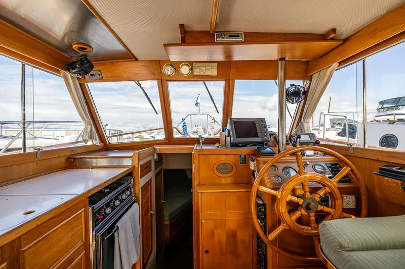 Vesper Yacht Photos Pics 1990 Grand Banks Sedan interior with wooden helm, navigation equipment, and galley.