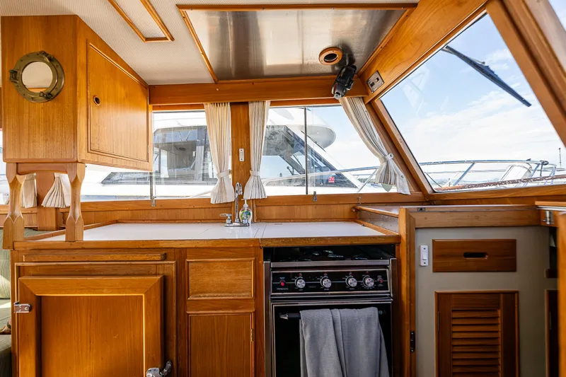 Vesper Yacht Photos Pics Interior of a 1990 Grand Banks Sedan yacht with wooden cabinetry and kitchen area.