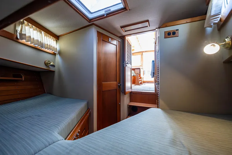 Vesper Yacht Photos Pics 1990 Grand Banks Sedan interior cabin with twin beds and wooden finishes.