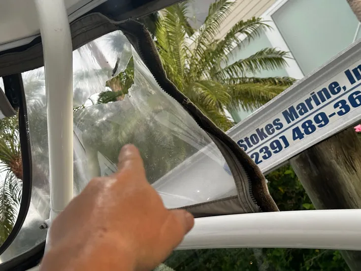 Tarpon III Yacht Photos Pics Hand pointing at damaged window on 2009 Cruisers Yachts 360 Express.