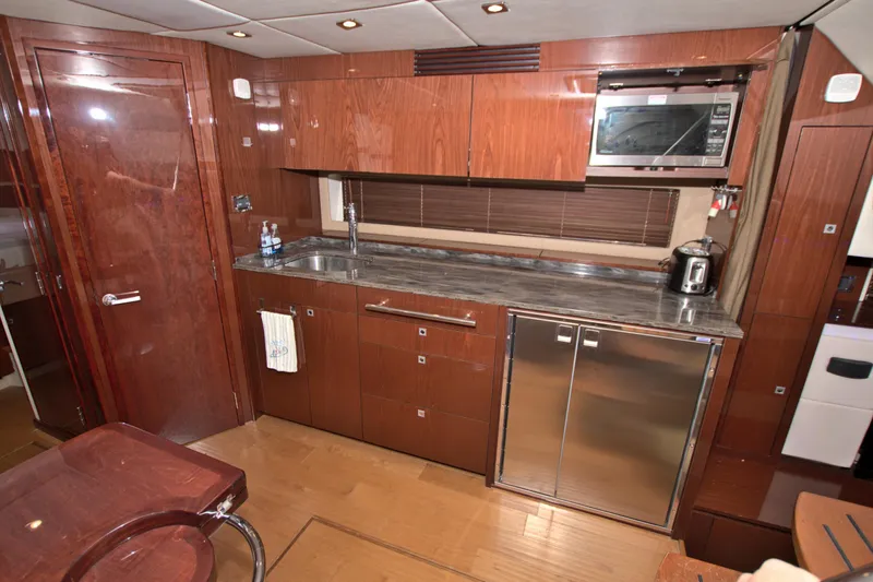 Sun Daze Yacht Photos Pics Luxurious kitchen interior of 2013 Sea Ray 450 Sundancer yacht with wood cabinetry and modern appliances.