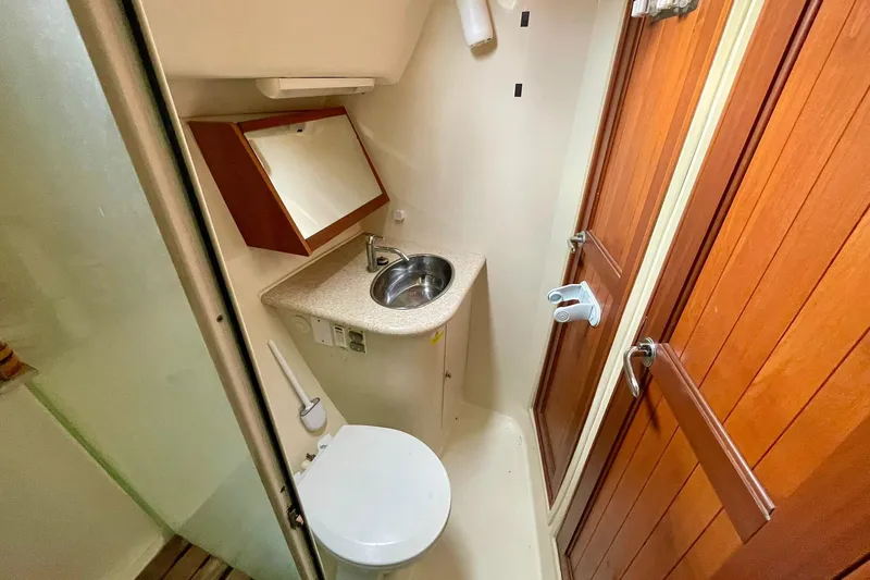  Yacht Photos Pics Compact bathroom in 2010 Hunter 45 Deck Salon yacht with sink, toilet, and wooden door.