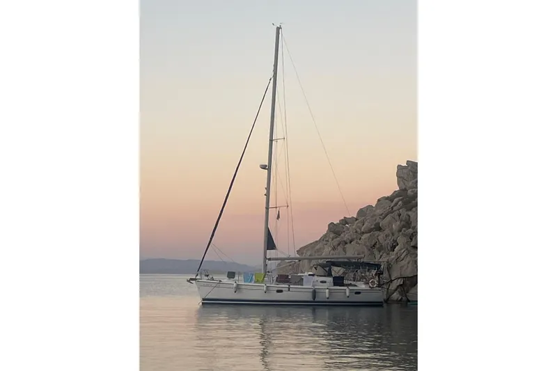 Yacht Photos Pics Sailboat Hunter 45 Deck Salon 2010 anchored at sunset near rocky shoreline.
