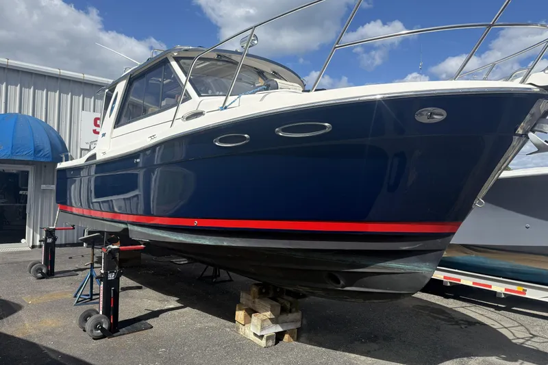  Yacht Photos Pics 2012 Cutwater C-28 boat on stands, blue hull with red stripe, outdoor setting.