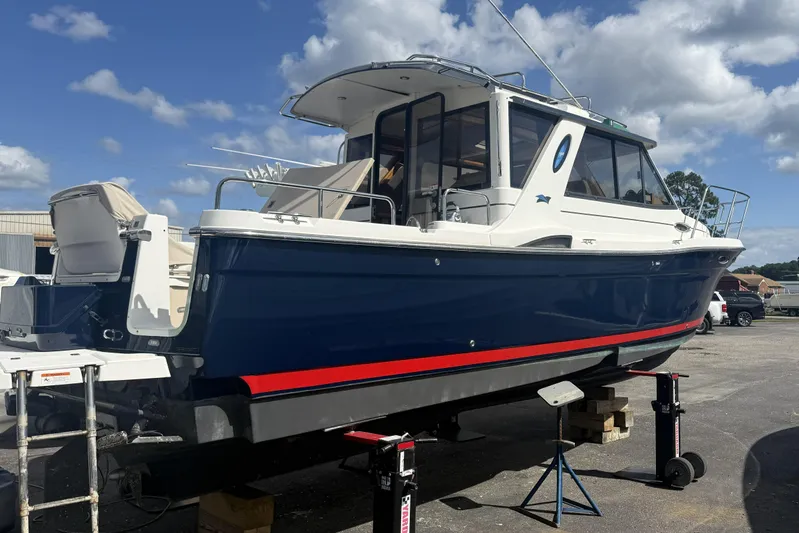  Yacht Photos Pics 2012 Cutwater C-28 boat on stands, blue hull, white cabin, clear sky background.