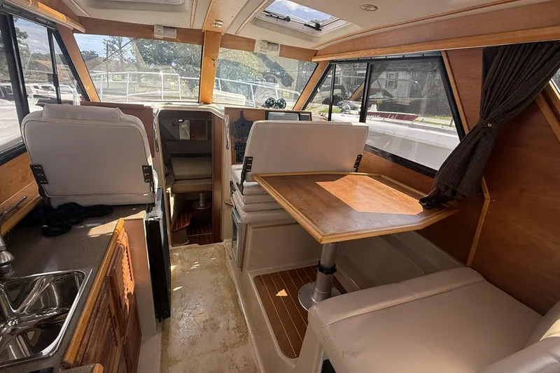  Yacht Photos Pics Interior of 2012 Cutwater C-28 boat with seating, table, and kitchenette.