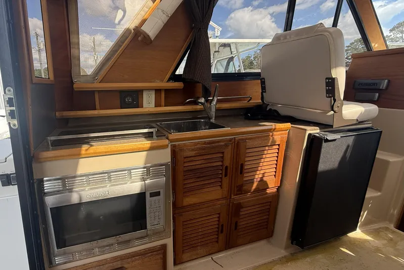  Yacht Photos Pics 2012 Cutwater C-28 boat interior with kitchenette, featuring microwave, sink, and seating.
