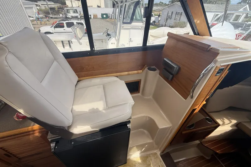  Yacht Photos Pics 2012 Cutwater C-28 interior helm with white seat and wooden accents.
