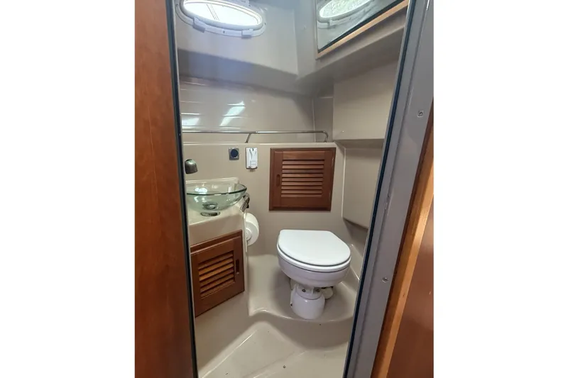  Yacht Photos Pics 2012 Cutwater C-28 boat bathroom with toilet, glass sink, and wooden accents.