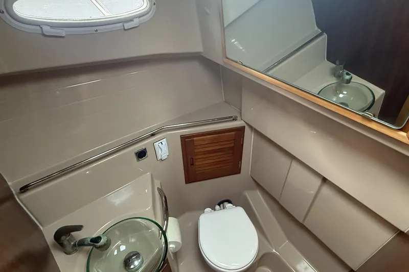  Yacht Photos Pics 2012 Cutwater C-28 boat bathroom with glass sink, toilet, and mirror.