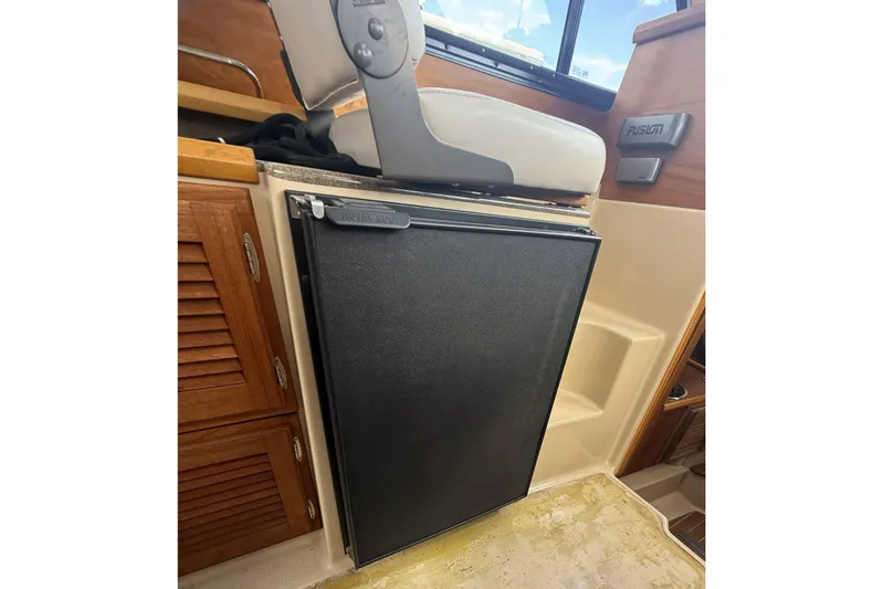  Yacht Photos Pics Interior of 2012 Cutwater C-28 boat featuring a compact refrigerator and wooden cabinetry.
