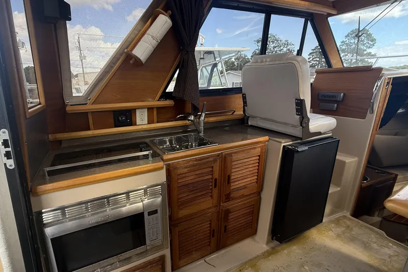  Yacht Photos Pics Interior of 2012 Cutwater C-28 boat featuring kitchen area with stove, sink, and seating.