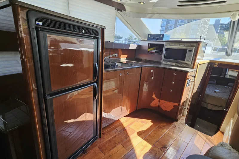  Yacht Photos Pics Luxurious 2012 Meridian 441 yacht kitchen with wood cabinetry, fridge, and microwave.