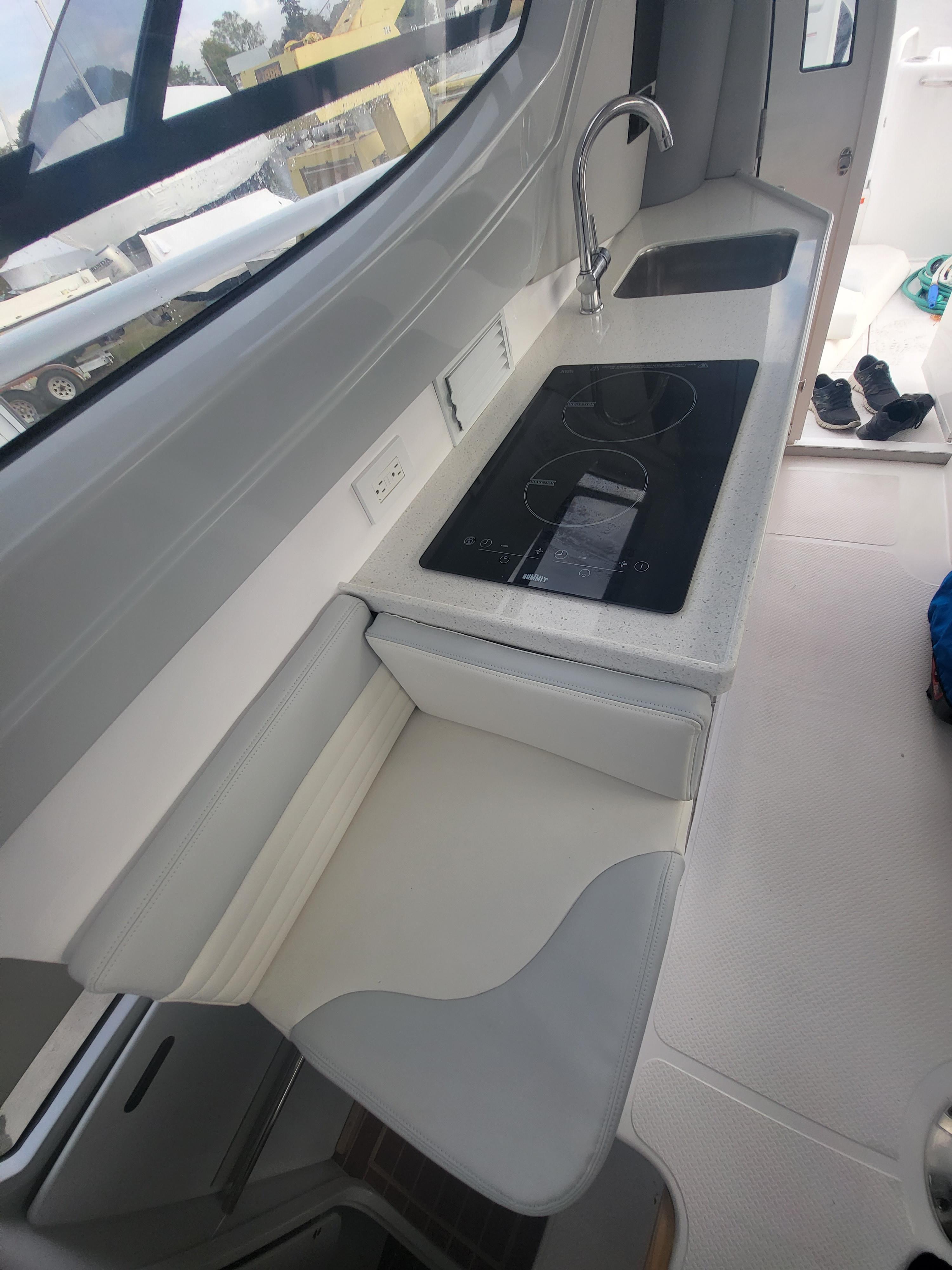 2024 ArrowCat 320 boat interior kitchen with stove and sink.