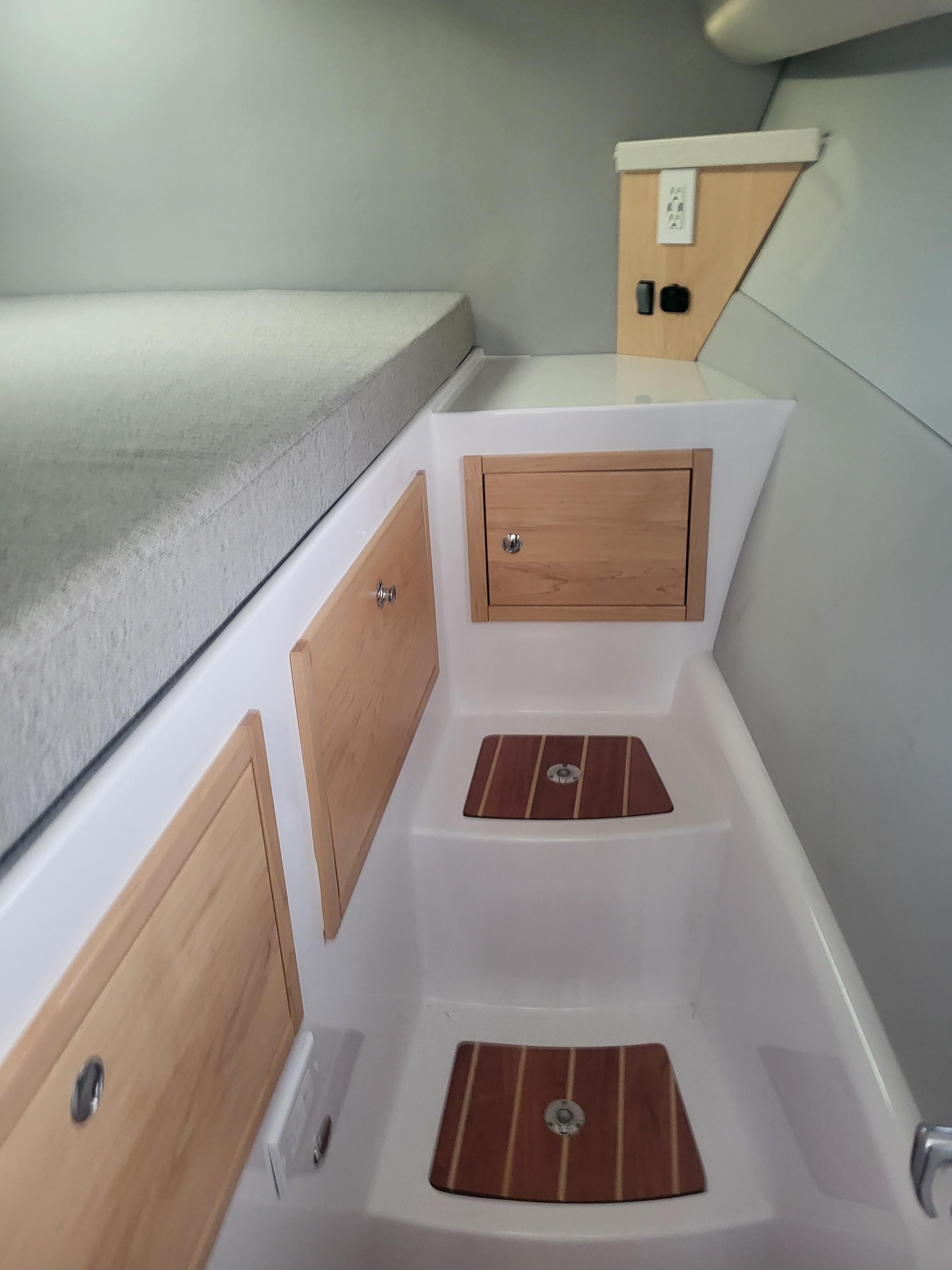 2024 ArrowCat 320 interior cabin with wooden storage compartments and steps.