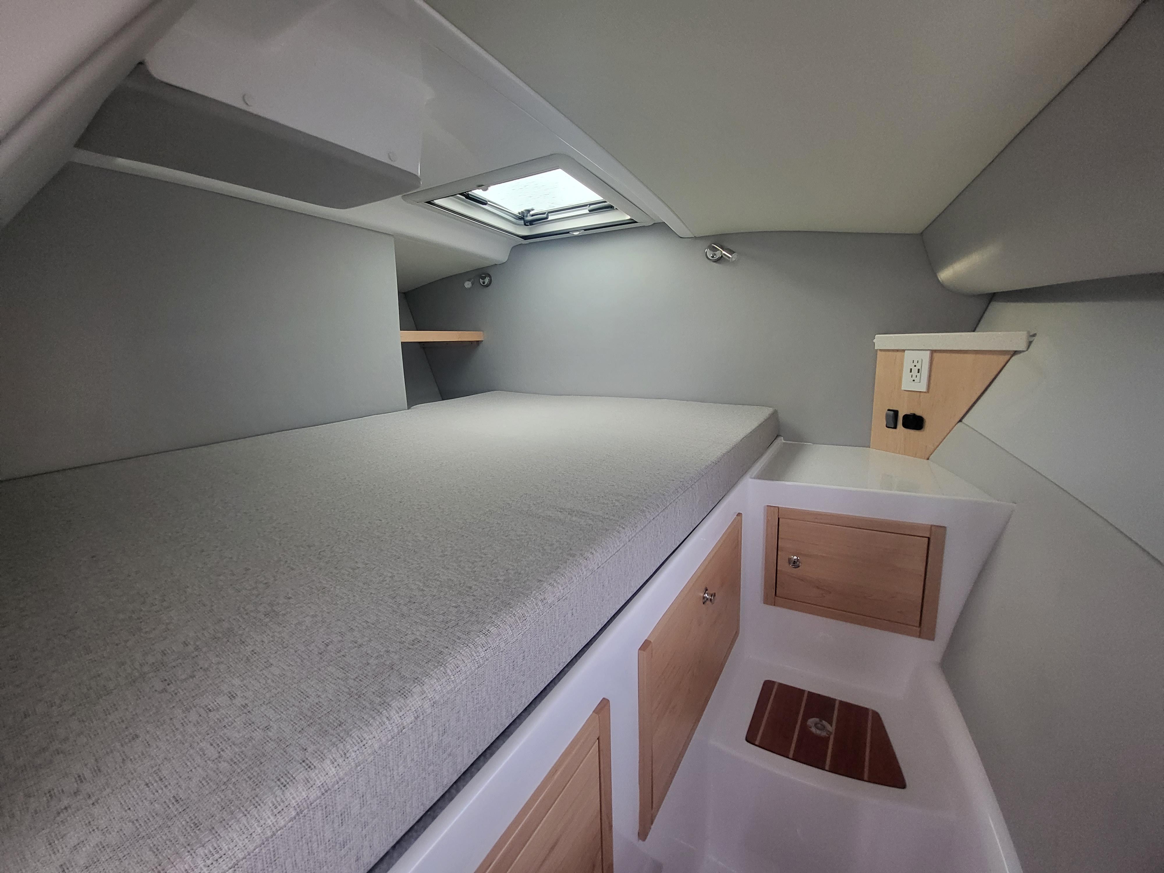 2024 ArrowCat 320 cabin interior with bed, storage, and skylight.