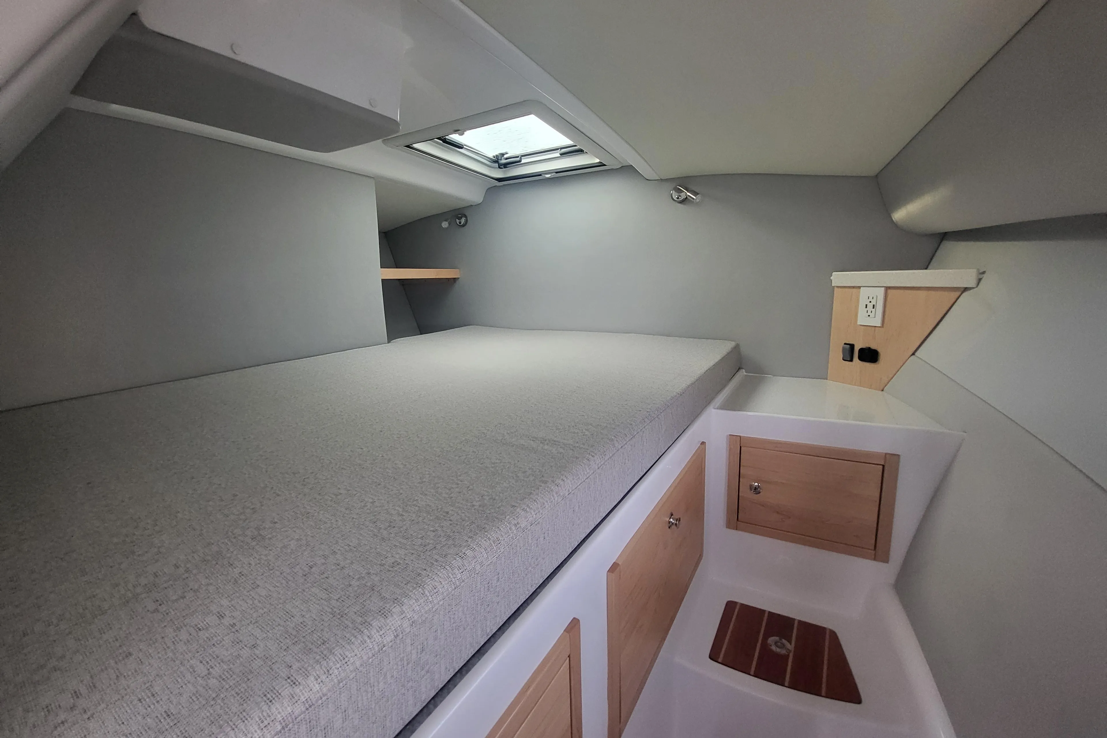 2024 ArrowCat 320 cabin interior with bed, storage, and skylight.
