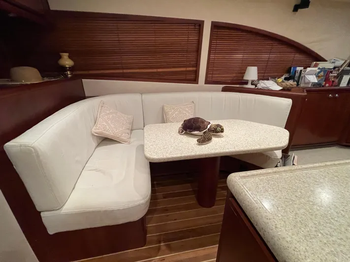  Yacht Photos Pics Interior of a 2005 Bertram 510 yacht with a cozy dining area and wooden accents.