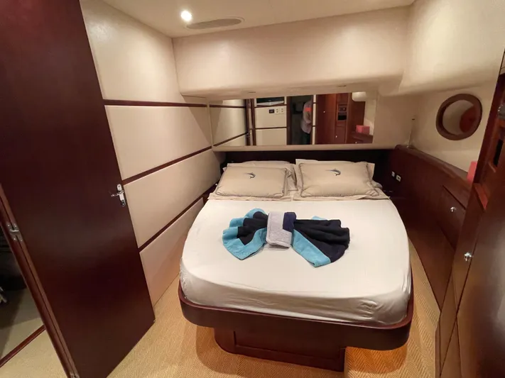  Yacht Photos Pics Luxurious bedroom interior of a 2005 Bertram 510 yacht with neatly arranged towels.