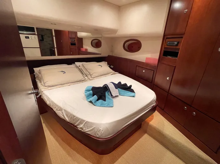  Yacht Photos Pics Luxurious cabin interior of 2005 Bertram 510 yacht with cozy bed and elegant wood finish.
