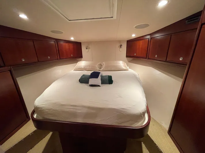  Yacht Photos Pics Luxurious cabin interior of 2005 Bertram 510 yacht with cozy bed and wooden cabinets.