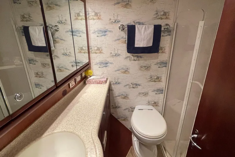  Yacht Photos Pics Bathroom interior of 2005 Bertram 510 yacht with nautical-themed wallpaper and modern fixtures.