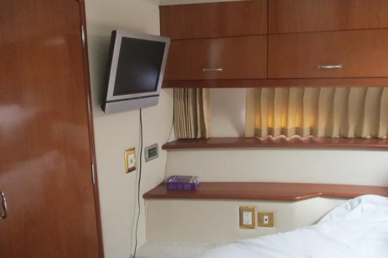  Yacht Photos Pics Interior of 2006 Carver 466 Motor Yacht with TV, wooden cabinets, and cozy bed.