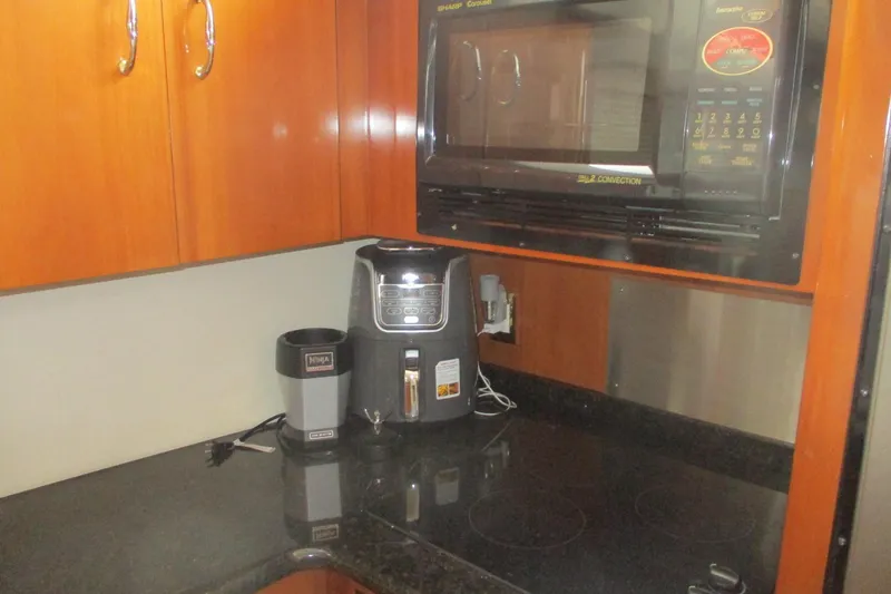  Yacht Photos Pics Kitchen area of 2006 Carver 466 Motor Yacht with appliances and wooden cabinets.