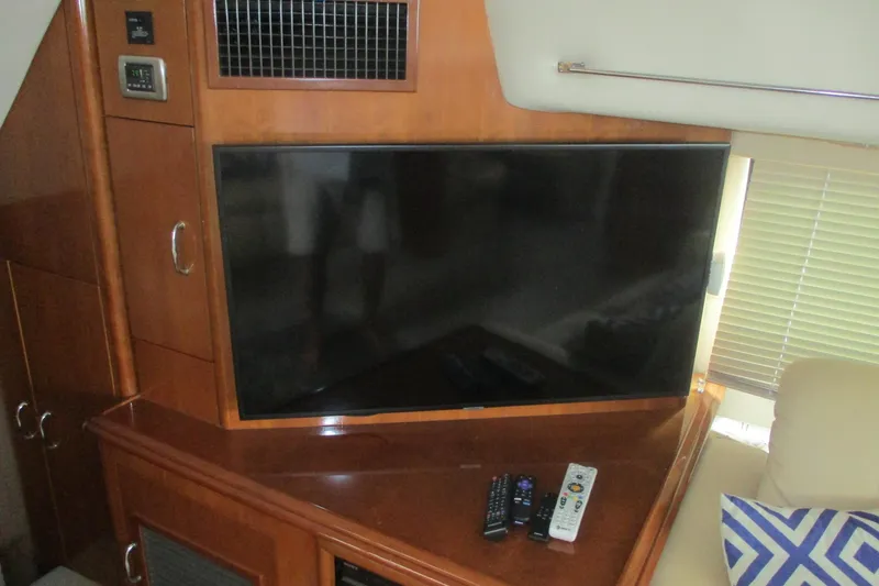  Yacht Photos Pics Flat-screen TV and remotes in 2006 Carver 466 Motor Yacht interior.