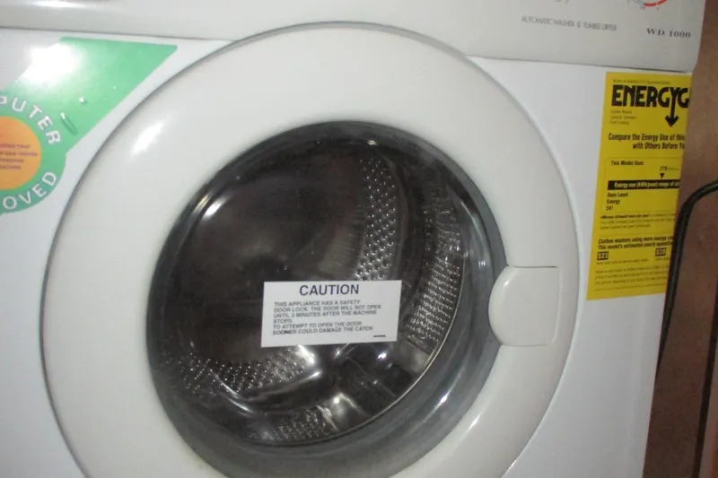  Yacht Photos Pics Front-loading washing machine with caution label and energy efficiency sticker.