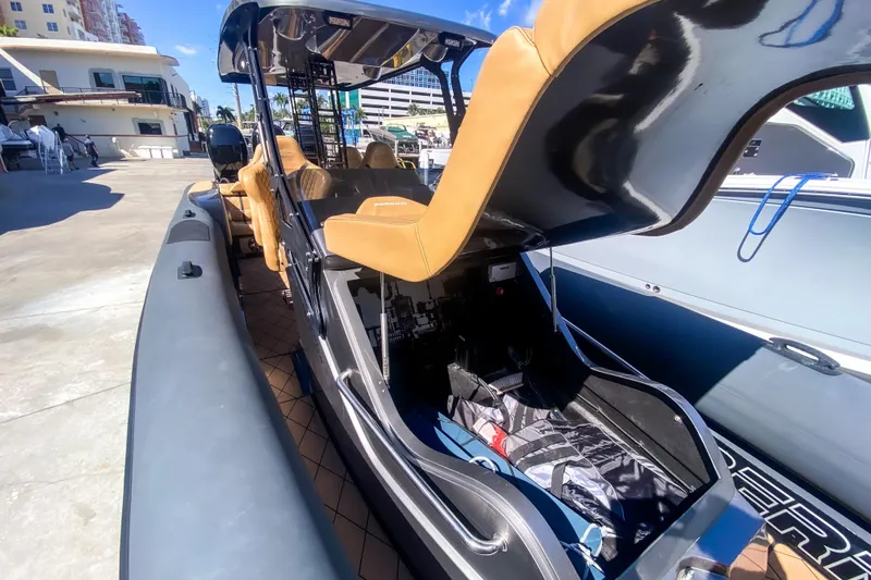  Yacht Photos Pics 2018 Bernico RX 10 boat with tan seats and open storage compartment at a marina.