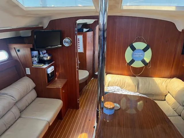 Yacht Photos Pics Interior of 1999 Hunter Passage 450 yacht with cozy seating and wooden finishes.