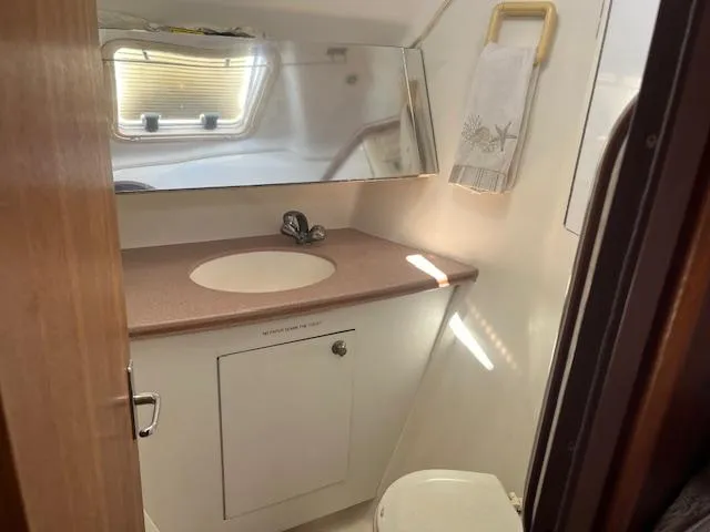  Yacht Photos Pics 1999 Hunter Passage 450 yacht bathroom with sink, mirror, and window.