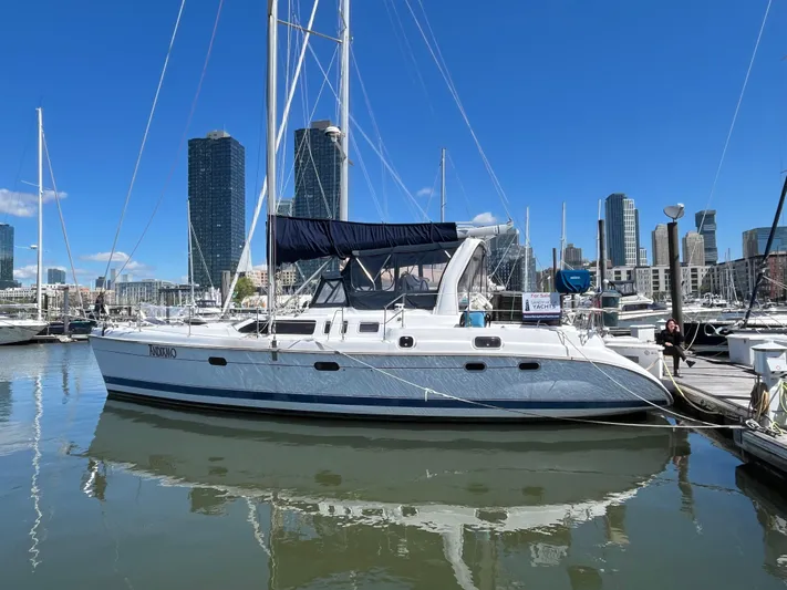  Yacht Photos Pics Sailboat docked in marina, 1999 Hunter Passage 450, with city skyline in background.