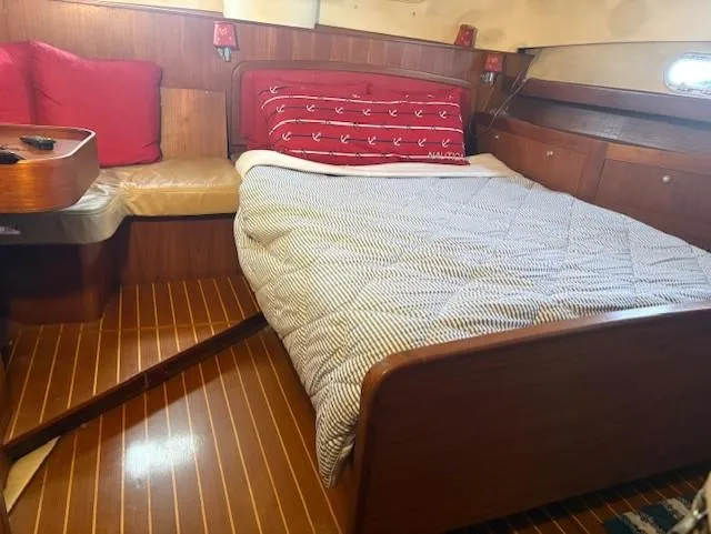  Yacht Photos Pics Cozy cabin interior of 1999 Hunter Passage 450 yacht with bed and wooden furnishings.