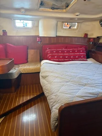  Yacht Photos Pics Cozy cabin interior of 1999 Hunter Passage 450 sailboat with bed and seating area.