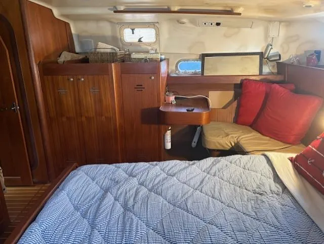 Yacht Photos Pics 1999 Hunter Passage 450 yacht interior with bed, wooden cabinets, and red cushions.