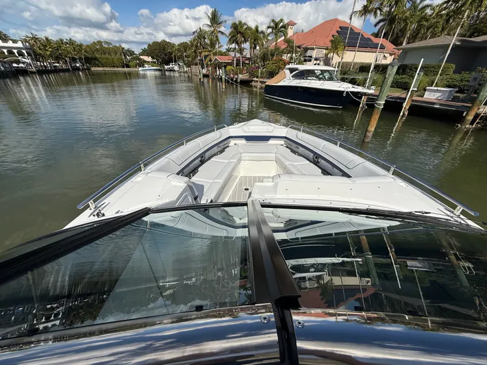 Sea Smoke Yacht Photos Pics 2023 Formula 330 CBR boat on calm water with palm trees in the background.