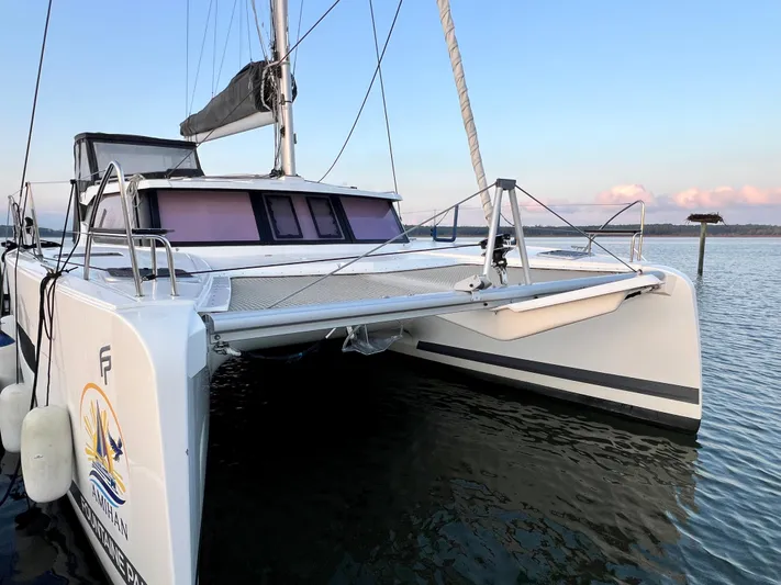 Amihan Yacht Photos Pics 2023 Fountaine Pajot Isla 40 catamaran docked on calm water at sunset.