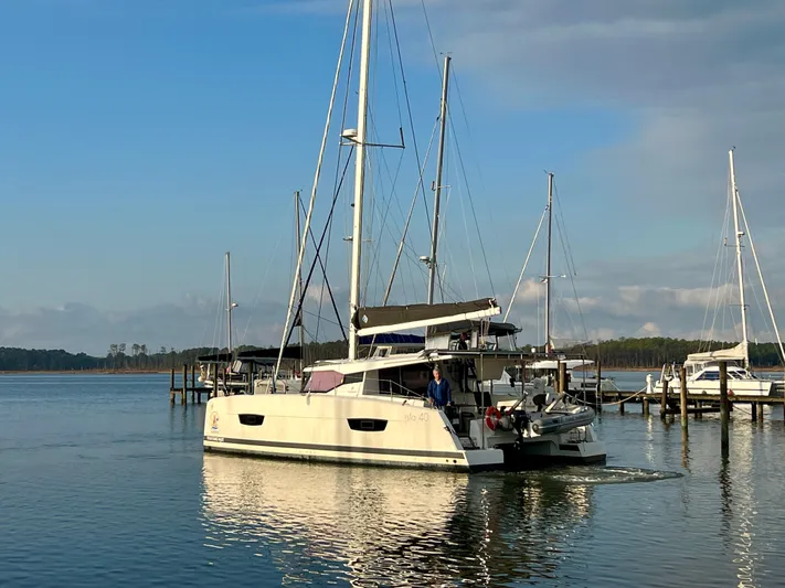 Amihan Yacht Photos Pics 2023 Fountaine Pajot Isla 40 catamaran sailing in a serene marina setting.