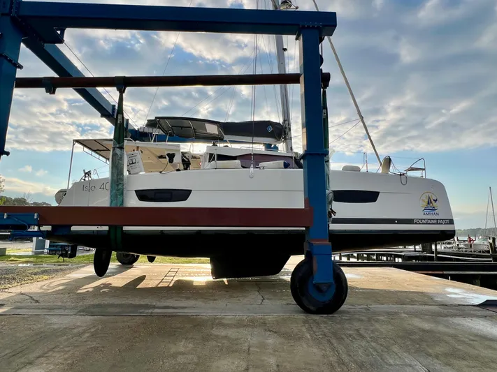 Amihan Yacht Photos Pics 2023 Fountaine Pajot Isla 40 catamaran on a lift at a marina.