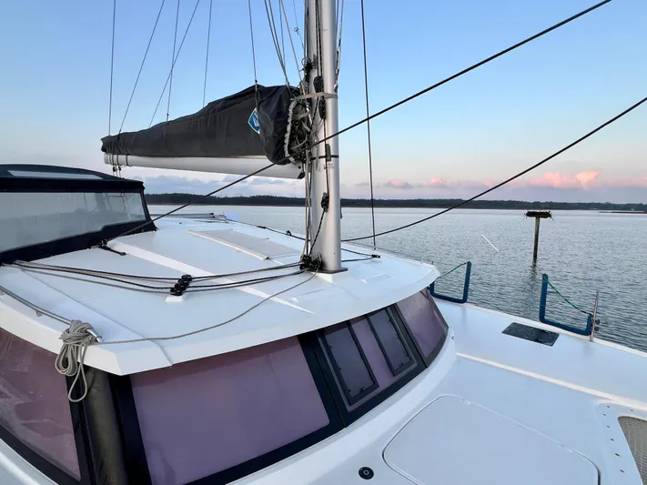 Amihan Yacht Photos Pics 2023 Fountaine Pajot Isla 40 catamaran on calm water at sunset.