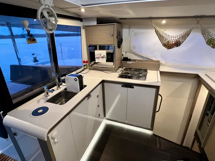 Amihan Yacht Photos Pics Modern kitchen interior of 2023 Fountaine Pajot Isla 40 catamaran with sleek design and appliances.