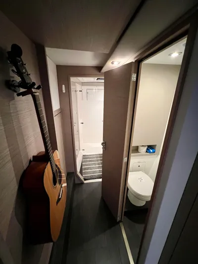 Amihan Yacht Photos Pics 2023 Fountaine Pajot Isla 40 interior with guitar, bathroom, and shower.