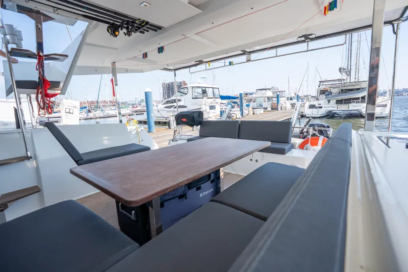 Amihan Yacht Photos Pics 2023 Fountaine Pajot Isla 40 catamaran interior with seating and table at marina.