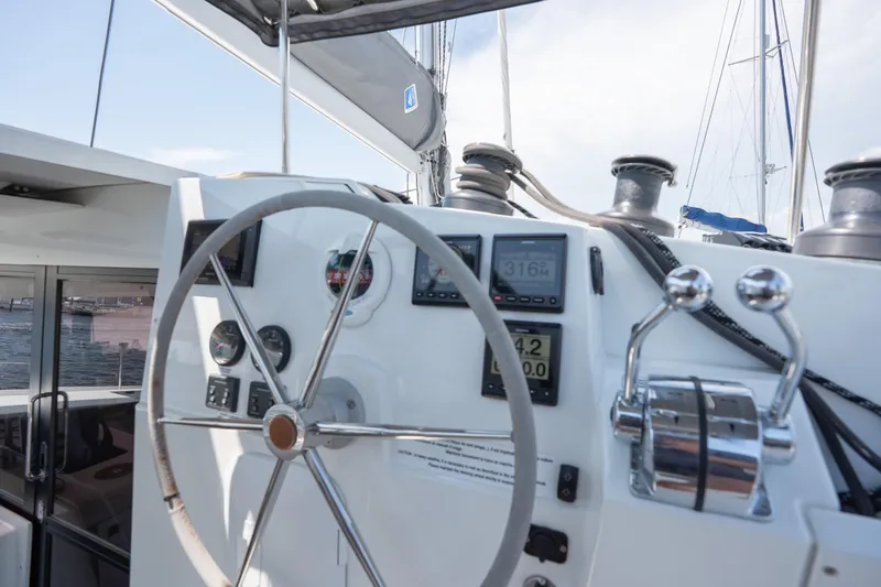 Amihan Yacht Photos Pics Helm of 2023 Fountaine Pajot Isla 40 catamaran with navigation instruments and steering wheel.